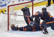 Edmonton Oilers' Zach Hyman (18) bats the puck out of the crease over Olilers goalie Mike Smith (41) during the second period of Game 3 of the NHL hockey Stanley Cup playoffs Western Conference finals against the Colorado Avalanche, Saturday, June 4, 2022, in Edmonton, Alberta. (Amber Bracken/The Canadian Press via AP)