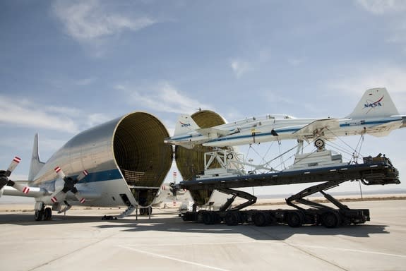 Two retired NASA T-38 trainers mounted on a transport pallet atop a mobile transporter are positioned for loading aboard NASA's Super Guppy prior to ferrying them to El Paso, Texas, for disassembly. Image released March 21, 2013.