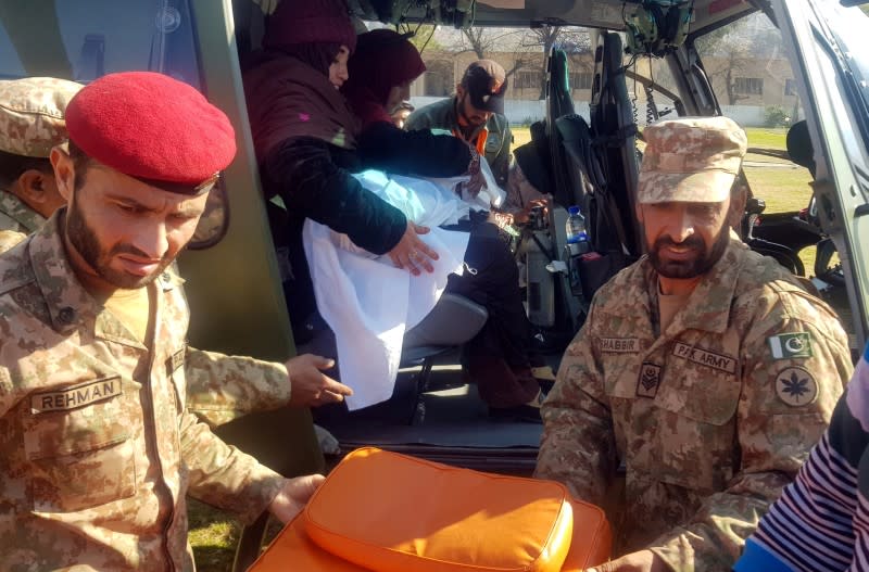 Army soldiers transport the body of six-year-old Safia Bibi in a helicopter in Muzaffarabad