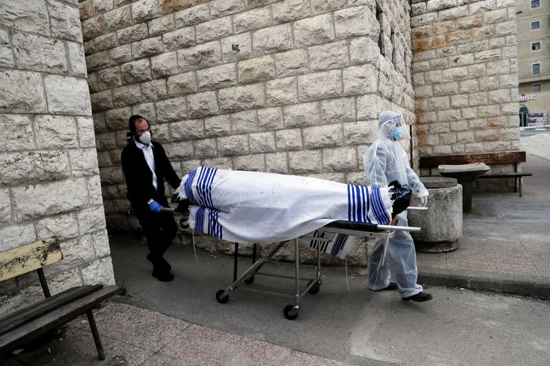 FILE PHOTO: Workers of Jewish Burial Society wear protective gear as they carry the body of a victim of coronavirus disease (COVID-19) to be buried in Jerusalem