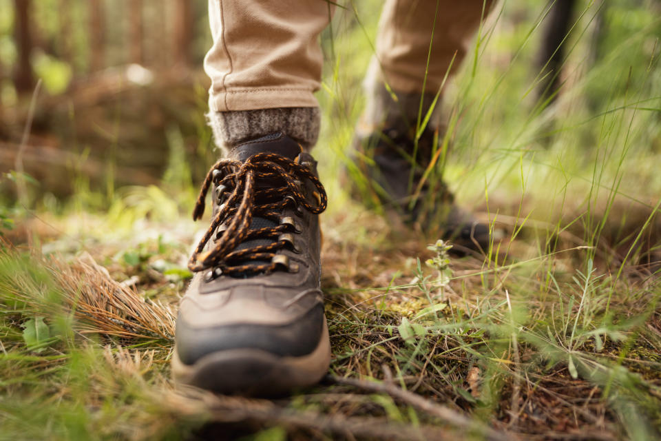 Young Caucasian female hiker taking a break after a long hike in the woods. Traveling concept.