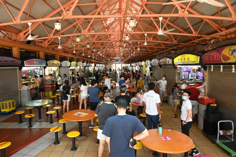 People, wearing face masks as a preventive measure against the spread of the COVID-19 novel coronavirus, queue to buy food at a hawker centre in Singapore on May 14, 2020. (Photo by Roslan RAHMAN / AFP) (Photo by ROSLAN RAHMAN/AFP via Getty Images)