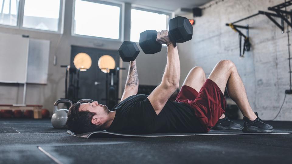 caucasian man doing exercises for the chest using dumbbels