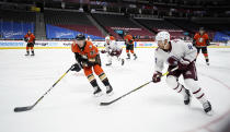 Anaheim Ducks defenseman Jacob Larsson, left, pursues the puck with Colorado Avalanche left wing Kiefer Sherwood in the first period of an NHL hockey game Friday, March 5, 2021, in Denver. (AP Photo/David Zalubowski)