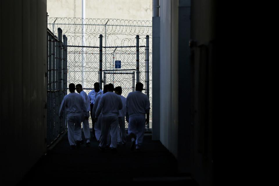 Detainees walk toward a fenced recreation area at a facility in Tacoma, Washington, in September 2019.