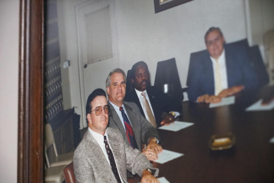 A photo of the late William Penn Troy Sr., second from right, and his fellow Marion County Council members, hangs on the wall of his office in Mullins, S.C., on Saturday, May 22, 2021. The funeral director died of COVID-19 in August 2020, one of many Black morticians to succumb during the pandemic. (AP Photo/Allen G. Breed)