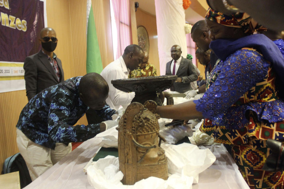 Benin bronzes looted in the past and returned to Nigeria are examined during a handing over ceremony in Abuja, Nigeria, Tuesday, Dec. 20, 2022. / Credit: Olamikan Gbemiga / AP