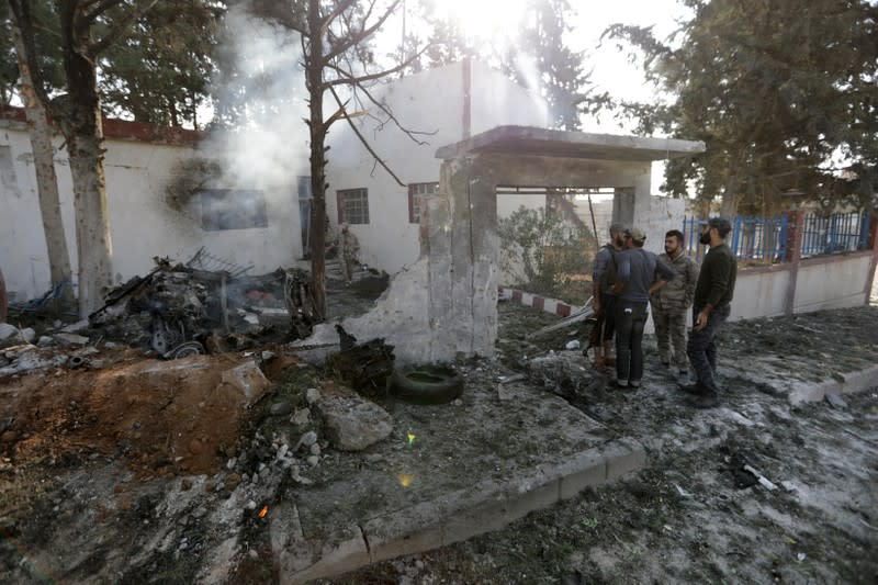 Turkey-backed Syrian rebel fighters inspect the site of an explosion in the town of Tal Abyad