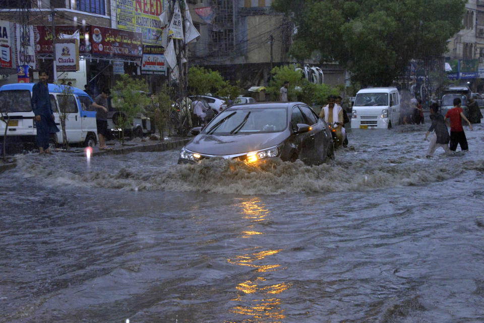 CORRECTS LOCATION TO HYDERABAD NOT KARACHI AND BYLINE TO PERVEZ MASIH Motorcyclists and cars drive through a flooded road caused by heavy monsoon rainfall in Hyderabad, Pakistan, Sunday, July 23, 2023. (AP Photo/Pervez Masih)