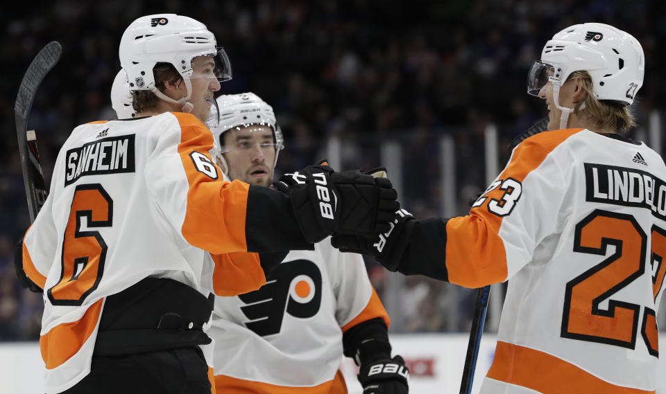 Philadelphia Flyers defenseman Travis Sanheim (6) celebrates with Flyers left wing Oskar Lindblom (23) as Flyers defenseman Robert Hagg, center, looks on after Sanheim scored the Flyers' second goal during the first period of an NHL hockey game, Sunday, March 3, 2019, in Uniondale, N.Y. (AP Photo/Kathy Willens)