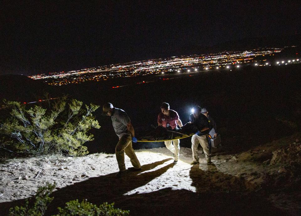 The body of a young woman is recovered by Ciudad Juárez forensic officials after she was found dead in a canyon just south of the international boundary. In the background, the lights of Sunland Park, New Mexico, can be seen.