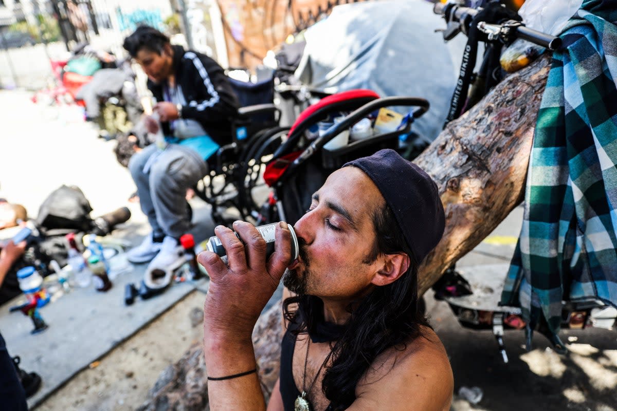 A homeless man named Angel drinks a soda to keep cool during a heatwave in San Francisco on July 3 (AP)