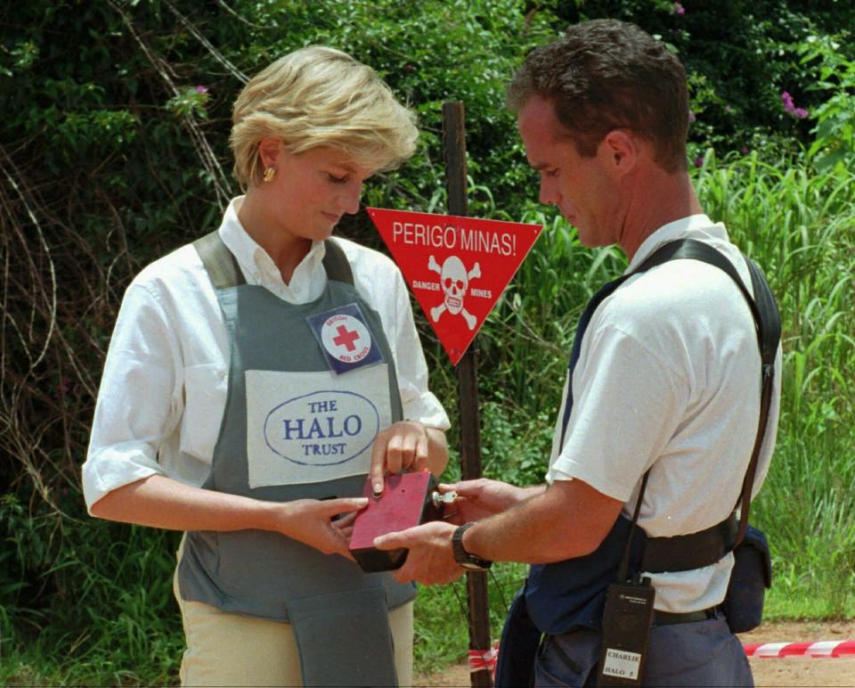 FILE - In this Jan. 15, 1997 file photo, Britain's Princess Diana uses a remote switch to trigger the detonation of some explosive ordinance dug up by mine sweepers in Huambo, Angola. Prince Harry is offering his support to Angola’s new 47 million pound ($60 million) initiative to clear land-mines, saying it will protect lives and help communities through conservation-led development. Speaking Monday, June 17, 2019 at the Chatham House think tank, Harry picked up the mantle for a cause near to the heart of his mother, the late Princess Diana, who worked with the Halo Trust on de-mining issues. (AP Photo/Giovanni Diffidenti, File)