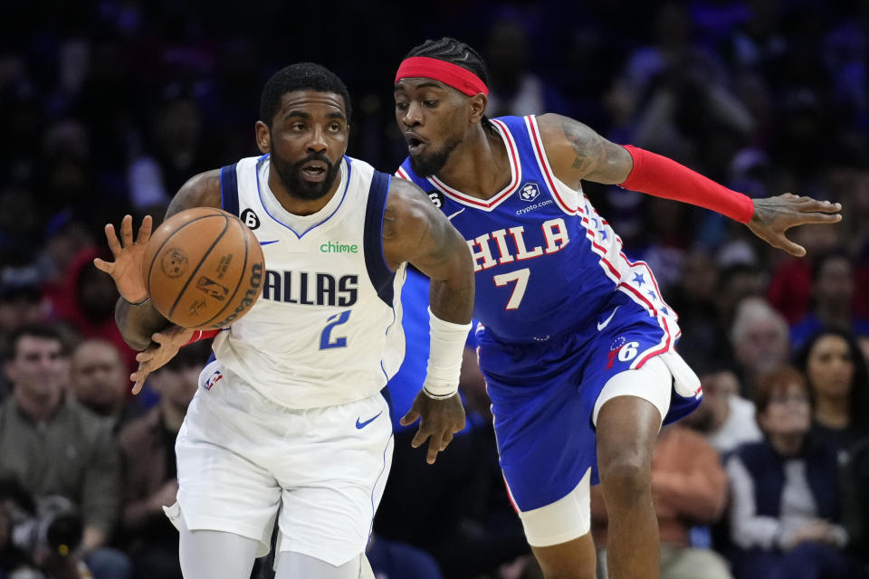 Philadelphia 76ers' Jalen McDaniels, right, tries to get the ball from Dallas Mavericks' Kyrie Irving during the first half of an NBA basketball game, Wednesday, March 29, 2023, in Philadelphia. (AP Photo/Matt Slocum)