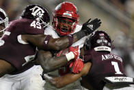New Mexico running back Jacory Croskey-Merritt (5) is tackled by Texas A&M linebacker Edgerrin Cooper (45) and defensive back Bryce Anderson (1) for a loss during the third quarter of an NCAA college football game Saturday, Sept. 2, 2023, in College Station, Texas. (AP Photo/Sam Craft)