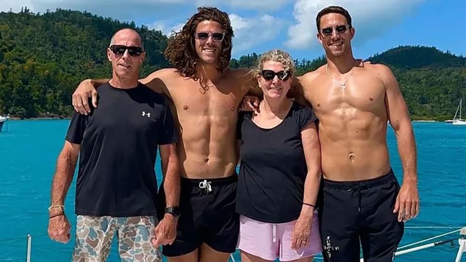 Callum and Jake Robinson pose with their parents on a boat