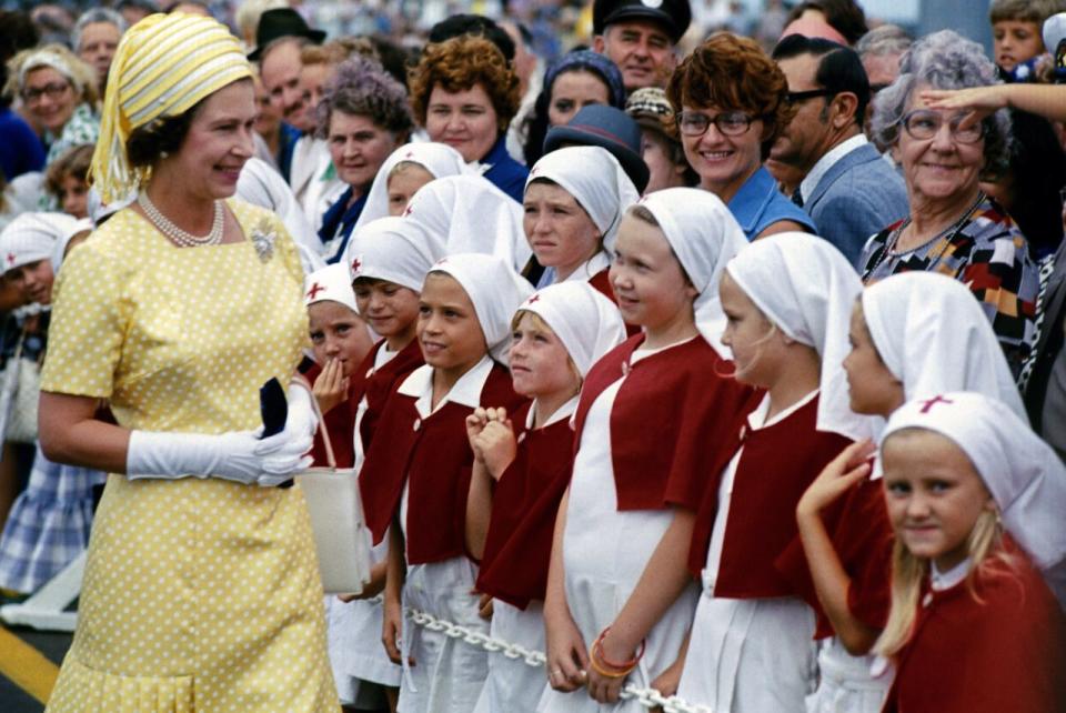 <p>Young schoolgirls in Brisbane greet The Queen during her Silver Jubilee tour of Australia. She celebrated the 25th anniversary of her accession to the throne this year. (PA Archive) </p>