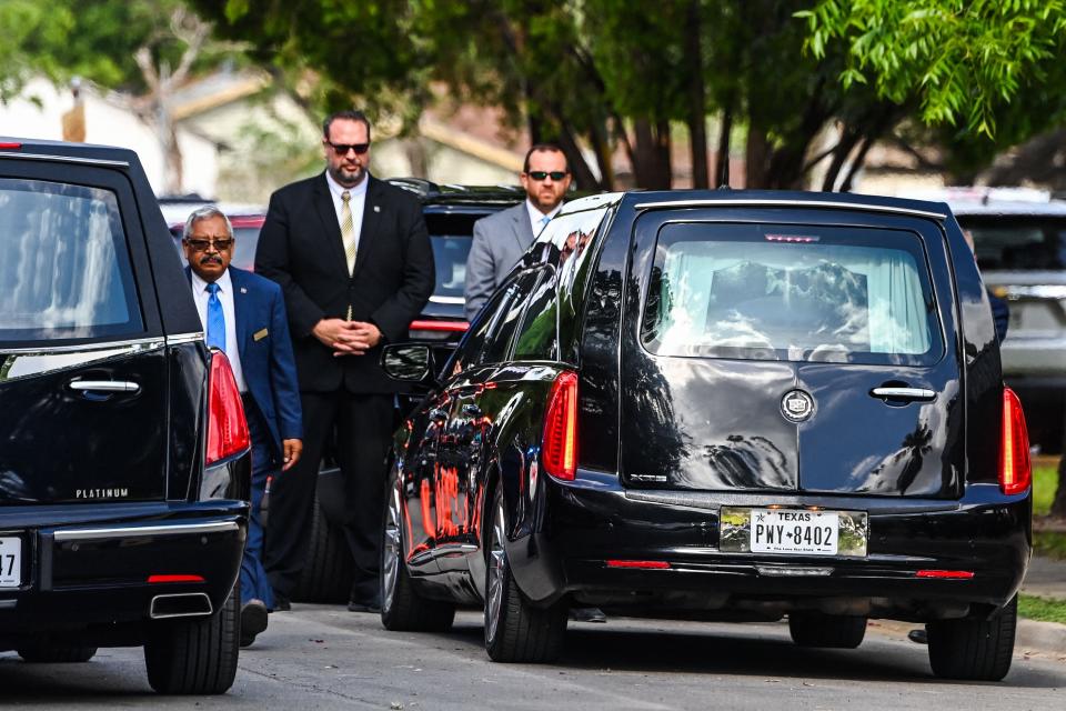 Cars carrying the casket of Irma Linda Garcia and Jose Antonio Garcia arrive at Sacred Heart Catholic Church in Uvalde, Texas, on Wednesday. Irma Garcia, a teacher, was killed in last week's elementary school shooting and her husband Joe Garcia died two days later of a heart attack.