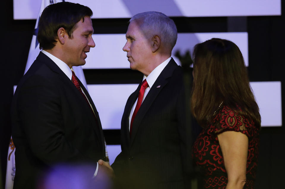 Vice President Mike Pence and Gov. Ron DeSantis shake hands before Pence speaks at Iglesia Doral Jesus Worship Center on the political crisis in Venezuela on Friday, Feb. 1, 2019, in Doral, Fla. (AP Photo/Brynn Anderson)