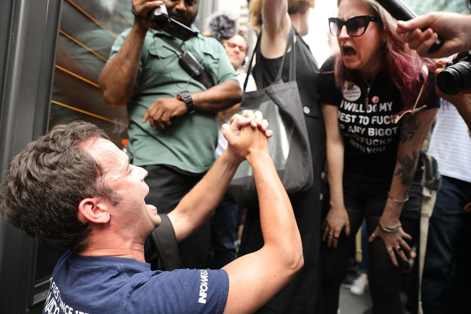 A President Donald Trump supporter (left) argues with anti-Trump protesters as they gather outside of Trump Tower.