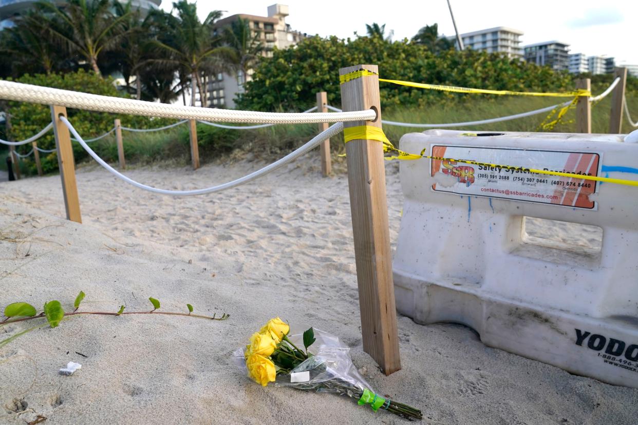 Flowers lie on the beach near the Champlain Towers South Condo building, Saturday, June 26, 2021, in the Surfside area of Miami. The apartment building partially collapsed on Thursday.