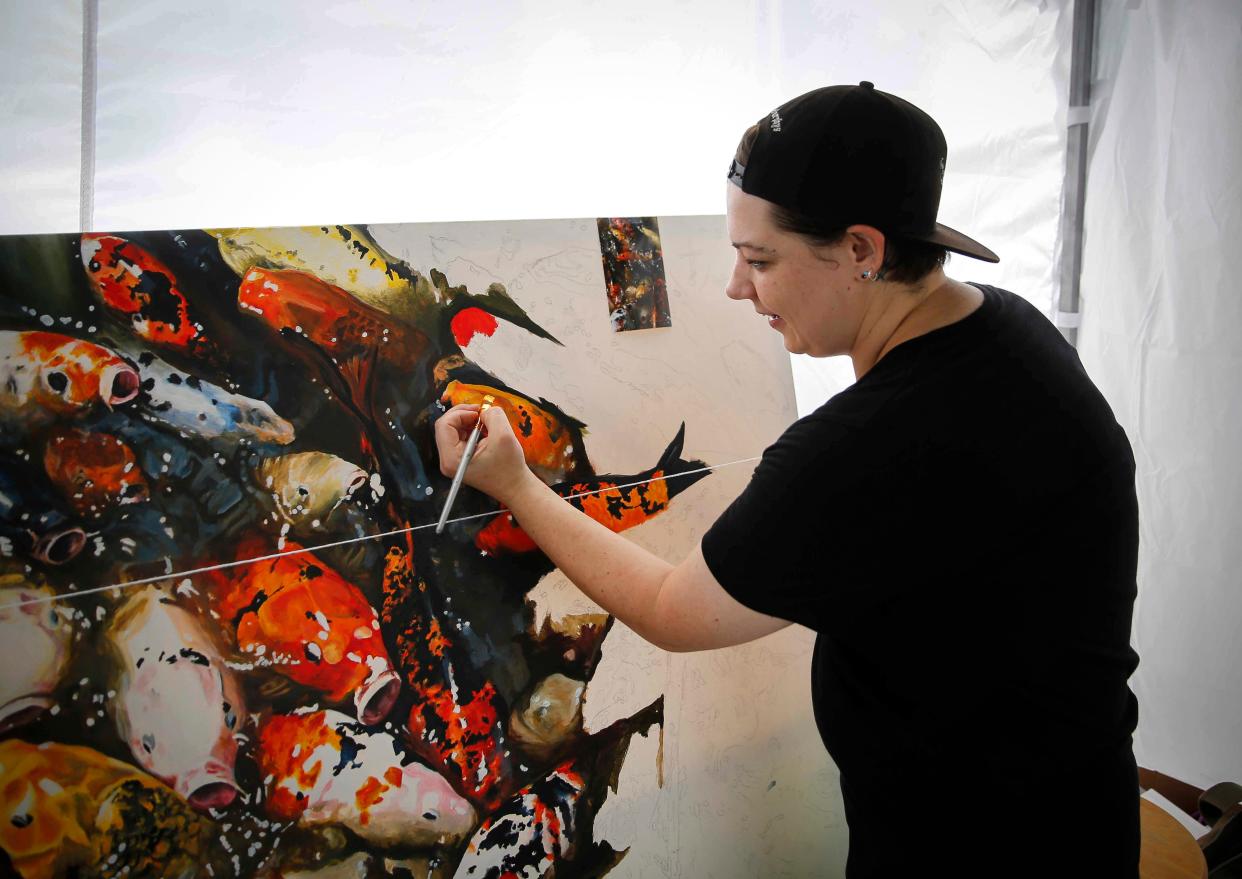 Des Moines artist Bethany Hiatt works on a highly detailed painting while working at her booth during the Waukee Art Festival on Saturday, July 17, 2021 at Centennial Park in Waukee.