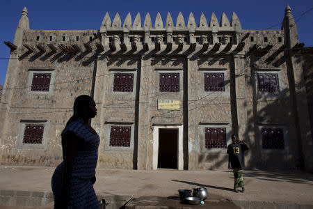 A woman walks by an Islamic institute in traditional Moorish style in Djenne, Mali September 1, 2012. REUTERS/Joe Penney