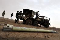 Libyan rebels stand with a missile launcher in the eastern city of Ajdabiya. Libyan leader Moamer Kadhafi suffered a major blow Wednesday with the defection of his foreign minister even as his forces again proved too strong for the rebels' rag-tag army