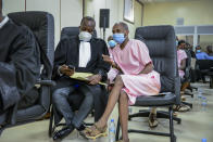 Co-accused Callixte Nsabimana, right, popularly known as Sankara, speaks to his lawyer Moise Nkundabarashi, left, at the trial of Paul Rusesabagina, who boycotted the announcement of the verdict, at a court in Kigali, Rwanda Monday, Sept. 20, 2021. Rusesabagina, the man who inspired the film "Hotel Rwanda" has been convicted of terrorism offenses and sentenced to 25 years in prison in a trial that human rights watchdogs and other critics of Rwanda's repressive government have described as an act of retaliation. (AP Photo/Muhizi Olivier)