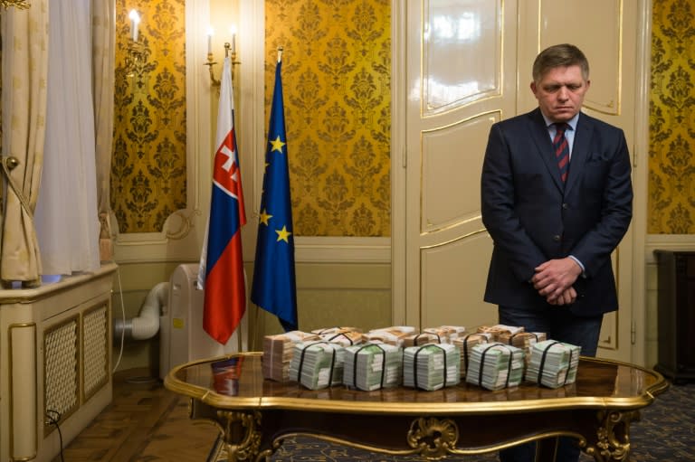 This file photo taken on February 27, 2018 shows Slovak Prime Minister Robert Fico, who has tendered his resignation, standing behind bundles of Euro banknotes during a press conference on the murder of a leading journalist who investigated high-profile tax fraud in Bratislava