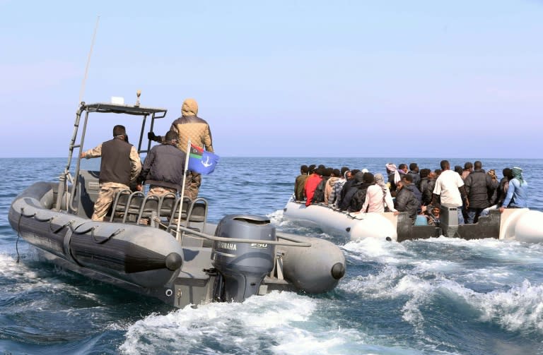 Libyan coast guards escort a boatload of migrants, who had hoped to set off to Europe with the help of people smugglers from the coastal town of Garabulli, on June 6, 2015