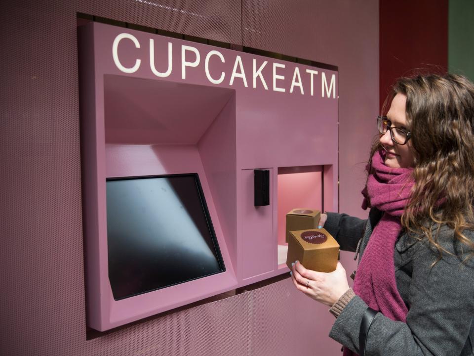 A customer uses a Cupcake ATM at Sprinkles Cupcakes.