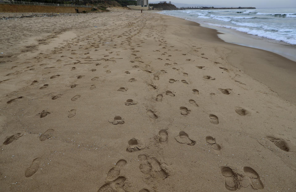 Footprints mark the sand on an empty Ramlet al-Baida public beach, during a lockdown that was imposed by the government to help stem the spread of the coronavirus, in Beirut, Lebanon, Wednesday, Jan. 27, 2021. Lebanon, a country of nearly 5 million and over 1 million refugees, is going through an unprecedented economic crisis that preceded the pandemic and restrictions imposed to combat it. (AP Photo/Hussein Malla)