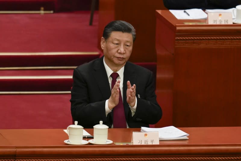 <cite>2024年3月5日。中國國家主席習近平在中國北京人民大會堂舉行的全國人民代表大會開幕式上致以鼓掌。（美聯社）</cite>