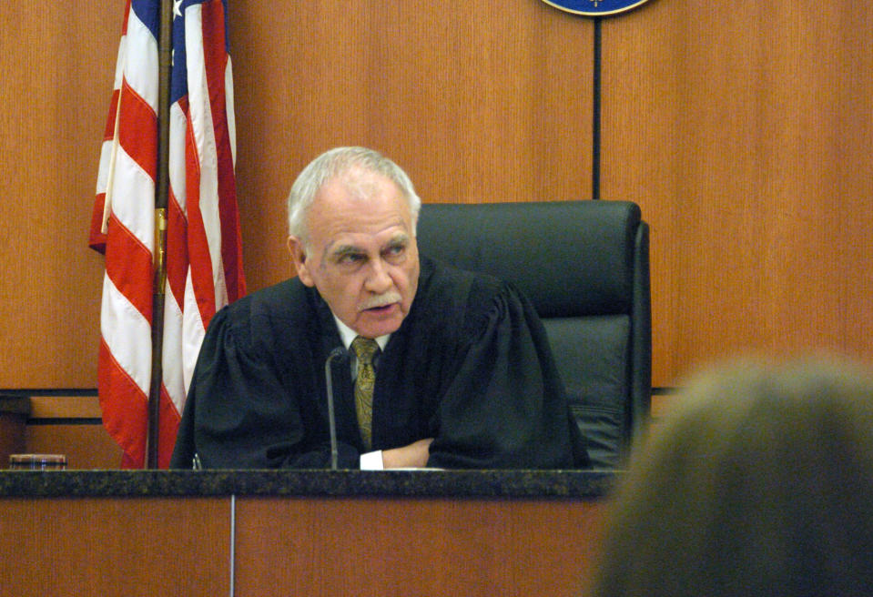 Montana District Judge Richard Simonton addresses a witness appearing via video during a competency hearing for murder suspect Michael Keith Spell Tuesday, March 25, 2014, in Sidney, Mont. Simonton will have to sort out competing claims about Spell's fitness for trial. (AP Photo/Matthew Brown)