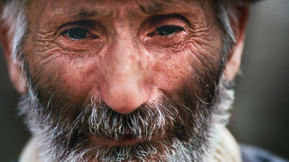 Hombre llora buscando a su hijo desaparecido tras la masacre de Jóyali en 1992.