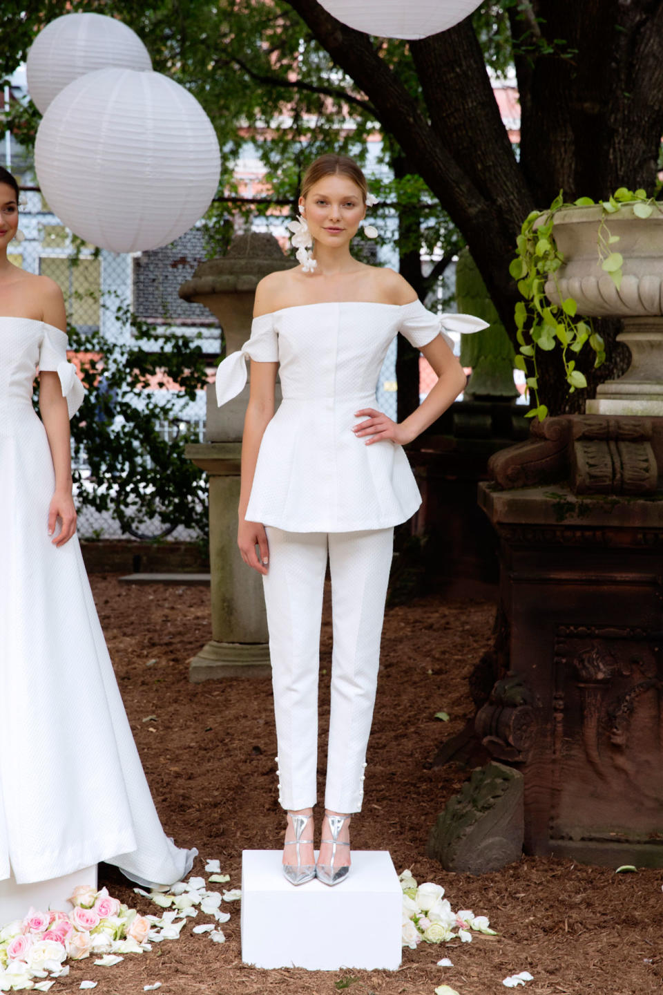 <p>A model wears a white off-the-shoulder blouser and matching pants from the Fall 2018 Bridal collection. (Photo: courtesy of Taylor Jewell, Nina Westervelt, Lela Rose) </p>