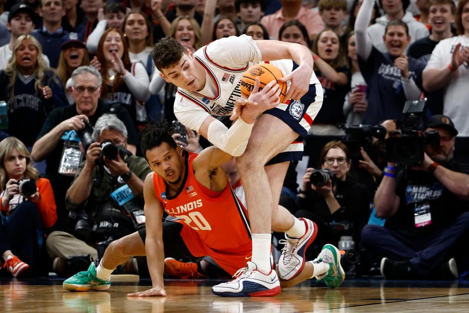 Connecticut center Donovan Clingan (32) grabs the ball away from Illinois forward Ty Rodgers (20) during the East Regional championship game of the 2024 NCAA men's tournament at TD Garden.
