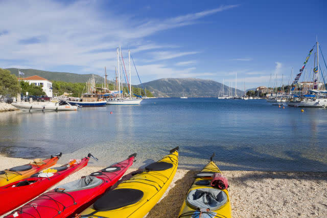 Greece, Kefalonia, Fiskardo, Kayaks in a row, on sunny beach