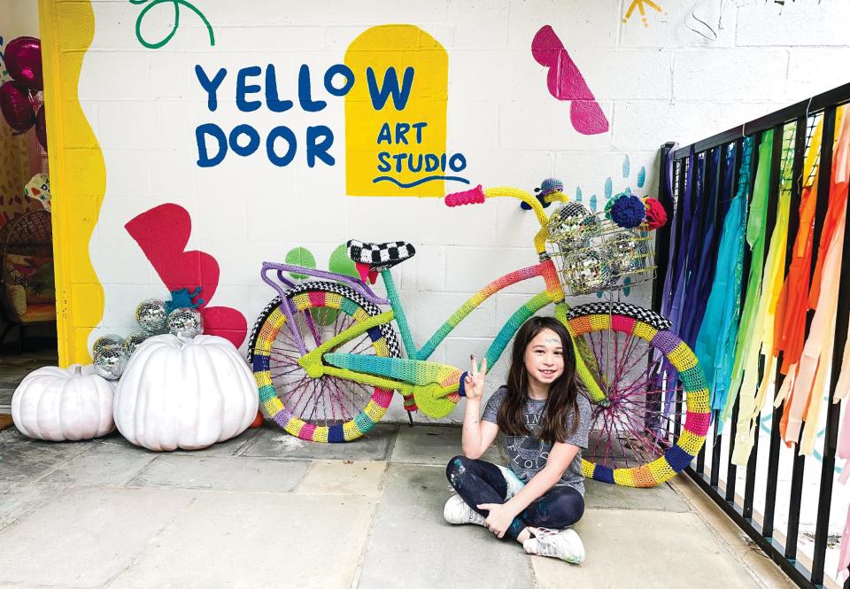 Lauren Mandal’s daughter, Simone, in front of Yellow Door Art Studio.