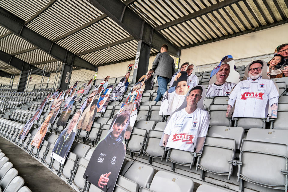 Pictures of soccer fans are placed in the stands as Ceres Park Football Stadium gets ready for the Danish Superliga match between AGF and Randers FC in Aarhus, Denmark, Wednesday May 27, 2020. FC Midtjylland and AGF Aarhus have gotten creative as they look to generate some atmosphere because games have to be played in empty stadiums. Midtjylland is planning a “drive-in” where about 2,000 supporters can watch games from inside their cars in a parking lot outside the team’s stadium. Aarhus is installing three giant screens along one side of the field displaying the faces of about 10,000 fans on a live video call. The first match of the Danish Superliga will be played Thursday evening May 28 in Aarhus. (Henning Bagger/Ritzau scanpix via AP)