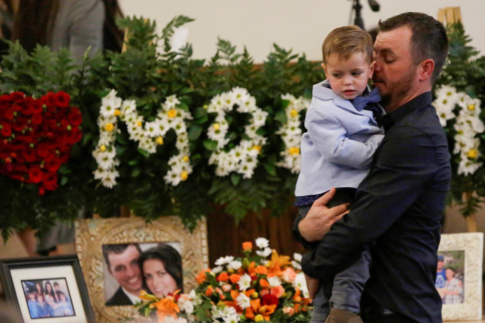 Tyler Johnson, the husband of Christina Marie Langford Johnson, who was killed by unknown assailants in Mexico on Nov. 4, holds a child during her funeral service in LeBaron, Chihuahua, Mexico. (Photo: Jose Luis Gonzalez / Reuters)