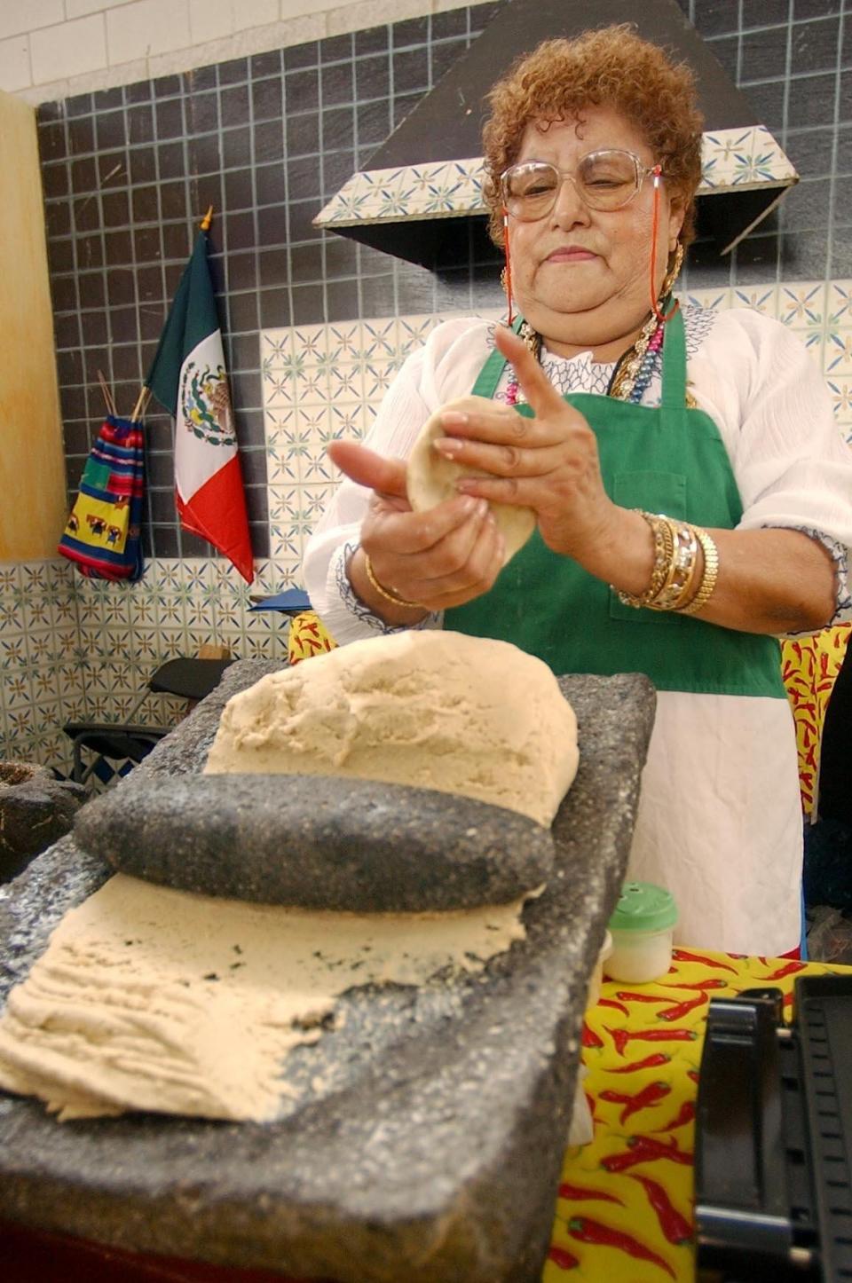 Ermina Olivarez of Milwaukee, prepares tortillas using a metate during Mexican Fiesta in 2004.