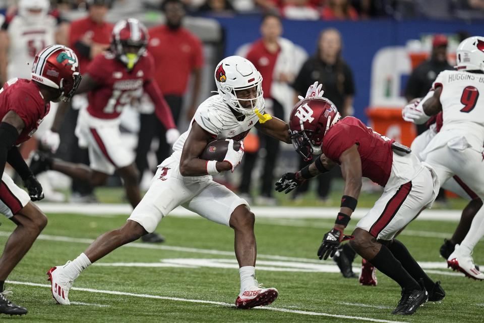 Louisville wide receiver Jamari Thrash (1) is tackled by Indiana defensive back Jamier Johnson (9) during the first half of an NCAA college football game, Saturday, Sept. 16, 2023, in Indianapolis. (AP Photo/Darron Cummings)