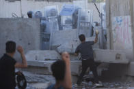 Iraqis throw stones during clashes with security forces in front of the Swedish embassy in Baghdad, Iraq, Thursday, July 20, 2023. The protest was in response to the burning of Quran in Sweden. (AP Photo/Hadi Mizban)