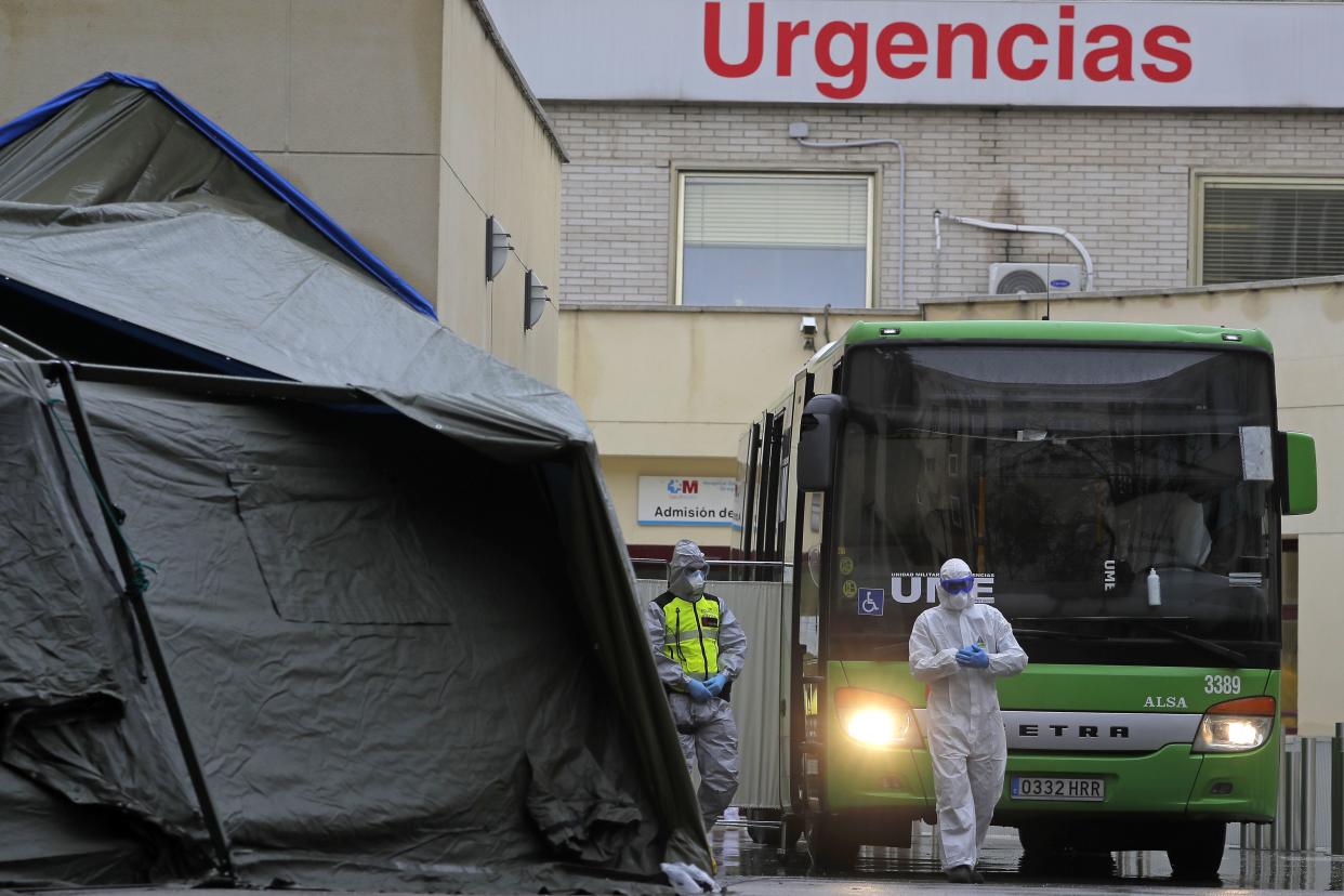 A member of the UME (Emergency Army Unit) wearing a protective suit to protect from the coronavirus stands next to a bus carrying patients infected with the COVID-19 waiting to be transported from Gregorio Maranon hospital to a temporary hospital set up at the IFEMA convention centre in Madrid, Spain, on Wednesday, April 1, 2020. Facing intense surges in the need for hospital ICU beds, European nations are on a hospital-building and medical worker-hiring spree. They are throwing together makeshift hospitals and shipping coronavirus patients out of overwhelmed cities.