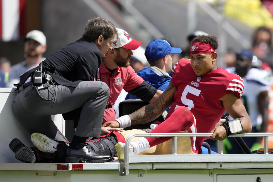 San Francisco 49ers quarterback Trey Lance (5) is carted off the field during the first half of an NFL football game against the Seattle Seahawks in Santa Clara, Calif., Sunday, Sept. 18, 2022. (AP Photo/Tony Avelar)