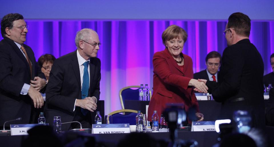 The German Chancellor Angela Merkel, meets with singer Bono, right, from the band U2, as President of the European Council Herman Van Rompuy, second from left, and President of the European Commission Jose Manuel Barroso, left, during the European People's Party Congress at the convention centre, Dublin, Ireland, Friday, March 7, 2014. (AP Photo/Peter Morrison)