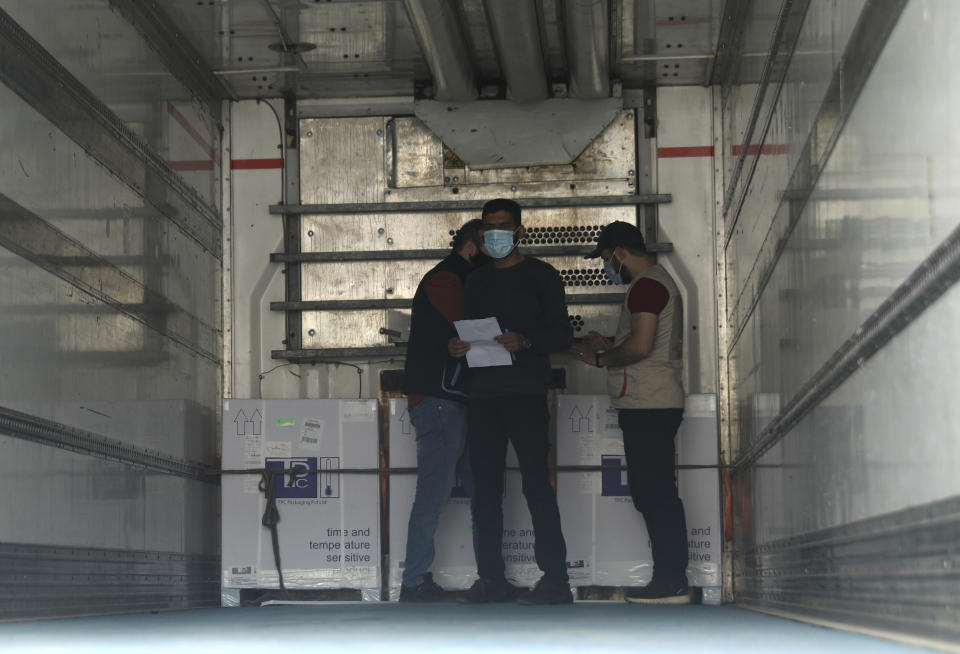 Heath workers check boxes of AstraZeneca COVID-19 vaccines inside a truck, that were delivered to Idlib through a border crossing with Turkey, in Bab Al-Hawa, northwestern Syria, Wednesday, April 21, 2021. Syria's last rebel-held enclave received its first batch of COVID-19 vaccines on Wednesday, with a refrigerated truck offloading over 50,000 of United Nations-secured jabs in the overcrowded province. (AP Photo/Ghaith Alsayed)