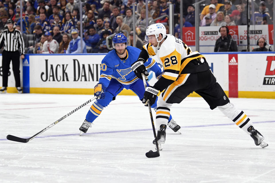 St. Louis Blues left wing Brandon Saad (20) pressures Pittsburgh Penguins defenseman Marcus Pettersson (28) during the second period of an NHL hockey game, Saturday, Feb. 25, 2023, in St. Louis. (AP Photo/Jeff Le)